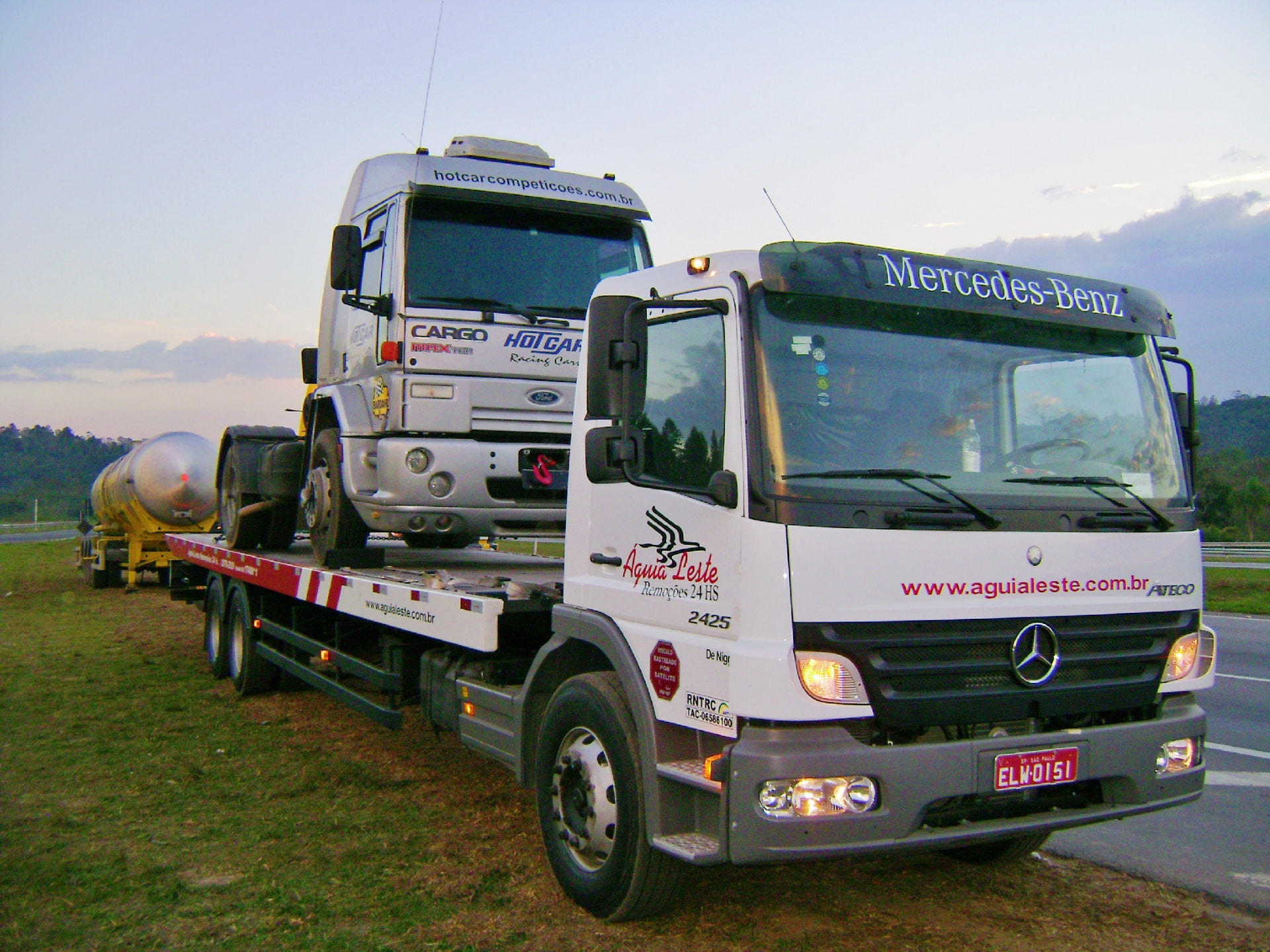 Guincho Águia Leste transportando caminhão Ford Cargo sobre prancha em rodovia